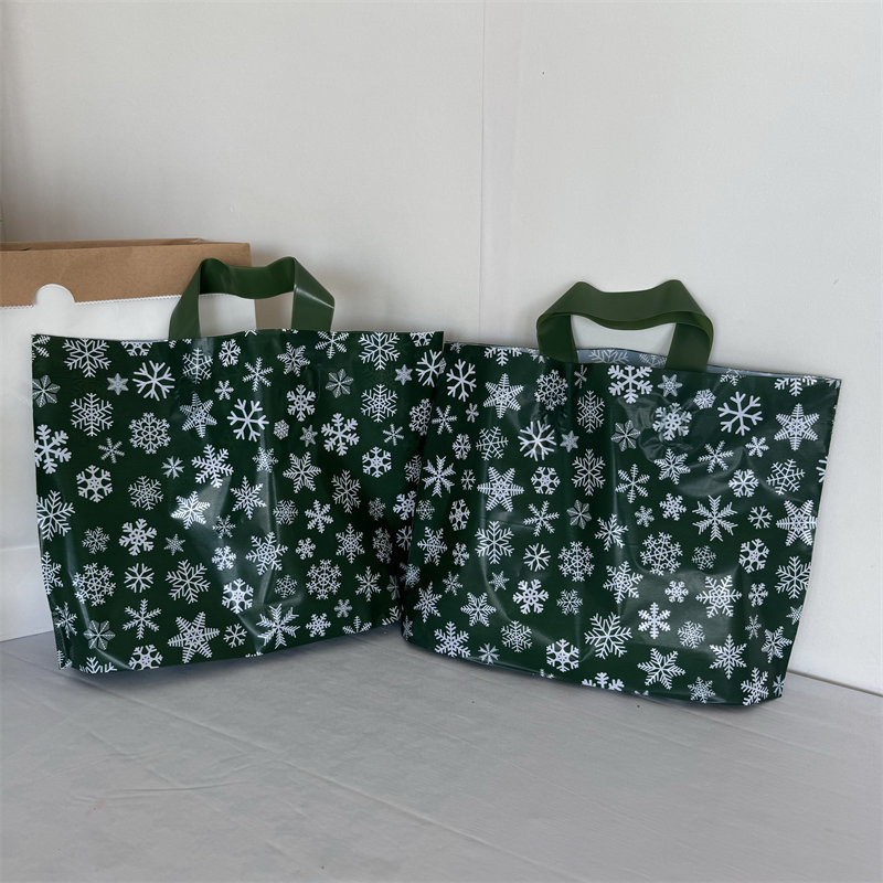 クリスマスの祝日の緑の厚いプラスチックの贈り物の服の店は手提げの袋の包装で厚いショッピングを包装して祝い事を包装します。|undefined