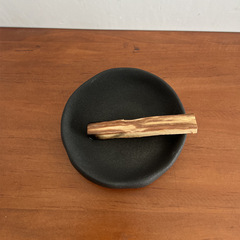 黒い陶磁器の聖木燃焼盤は香炉を隠します。