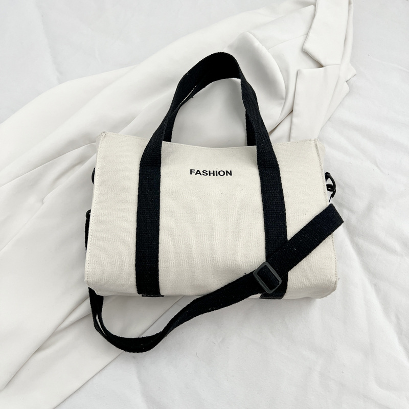 2024 nuevo simple japonés blanco y negro bolso de tela de gran capacidad para estudiantes de clase de viaje mochila de hombro