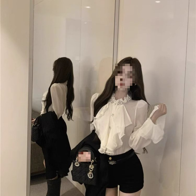 Women's elegant chiffon blouse with rhinestone ruffle collar, long sleeves, and fitted waist, perfect for autumn. Also includes black shorts.