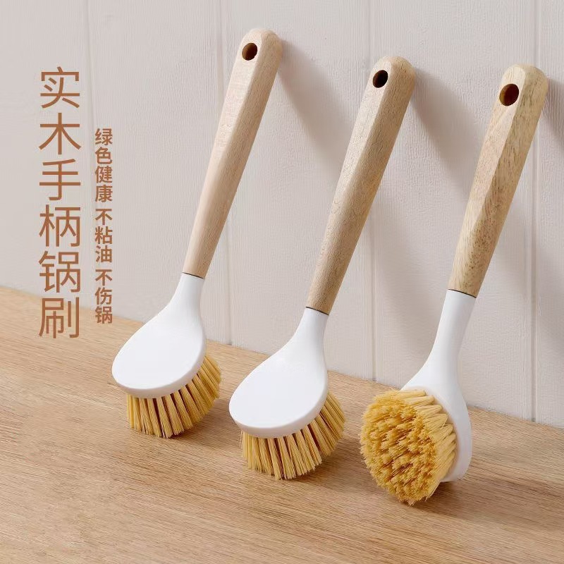長い柄の鍋は台所の家事をこすります。ケヤキの取っ手をきれいにします。|undefined