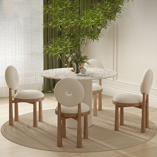 Trendy Instagram-worthy cream-colored lambswool chair set with Wabi-Sabi-style polished stone round dining table and chairs, perfect for compact spaces—featuring a sleek rock slab top paired with solid wood dining table.