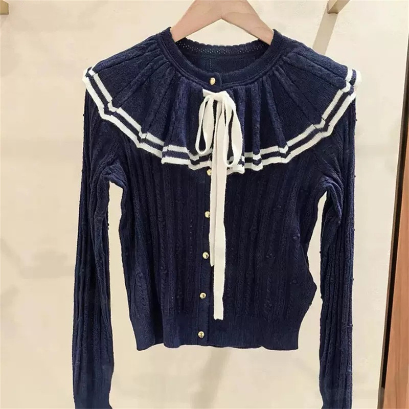 French-style, niche design: 2026 autumn/winter collection, dark blue, collegiate style, ribbed knit sweater with contrasting colors, ruffled trim, and a large, tied collar French-style, niche design: 2026 autumn/winter collection, dark blue, collegiate style, ribbed knit sweater with contrasting colors, ruffled trim, and a large, tied collar