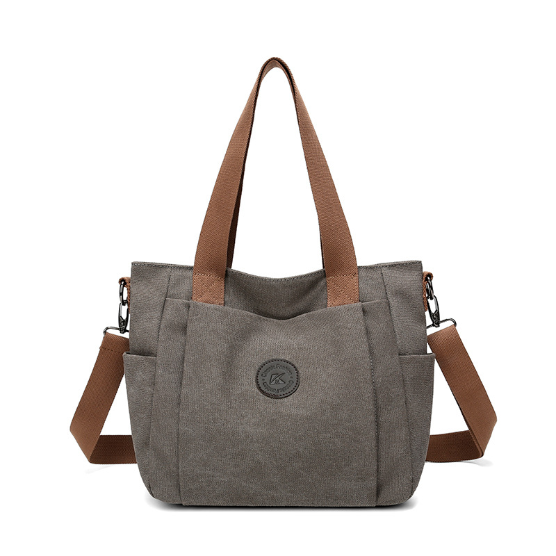 2025 bolsas de mujer europeas y estadounidenses transfronterizas nuevas bolsas de viaje de gran capacidad bolsas de hombro de lona de color sólido bolsas de brazo