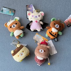 リラックマのハロウィーン熊の弟熊の妹の漫画のプリンの腰掛けのスタンドの手の玉のぬいぐるみの人形は飾りを包みます。