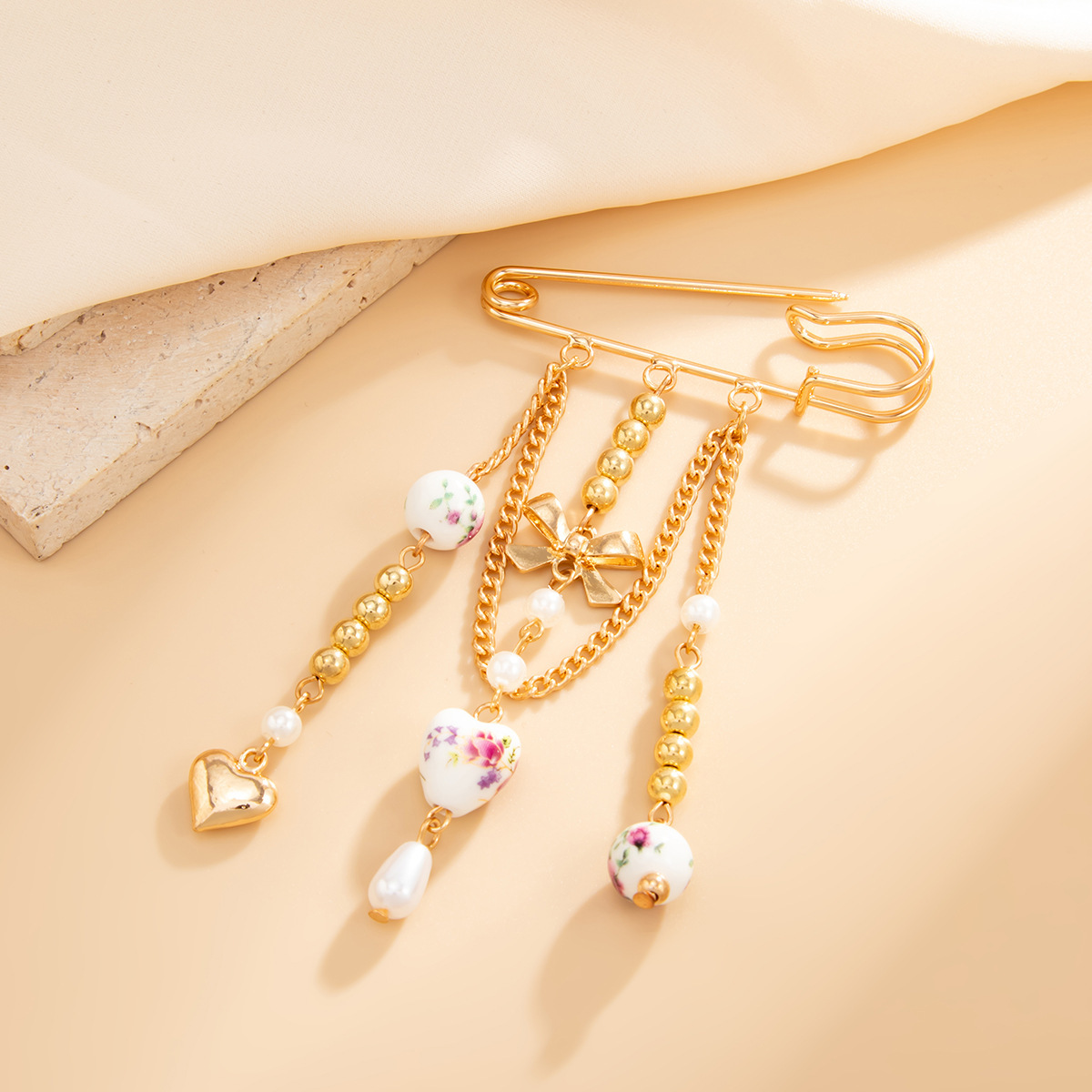 Spilla a forma di fiocco in ceramica con pendente a cuore_voghion.com