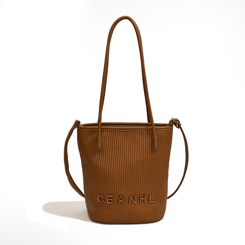 2025 otoño y invierno nuevo pequeño bolso a rayas de viento fragante bolso de cubo simple bolso de hombro de tendencia de mujeres bolso de mochila popular