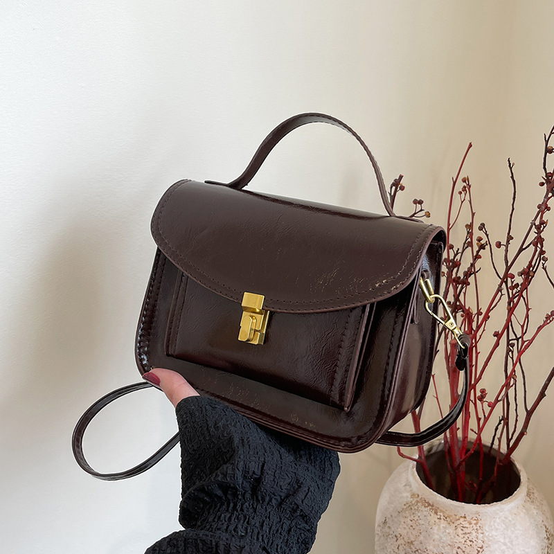 Este año, la popularidad de la bolsa de correo retro para mujeres 2025 nuevo cuero blando hombro simple bolso de mano universal