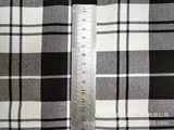 Эластичные черно -белые брюки клетку ткане
