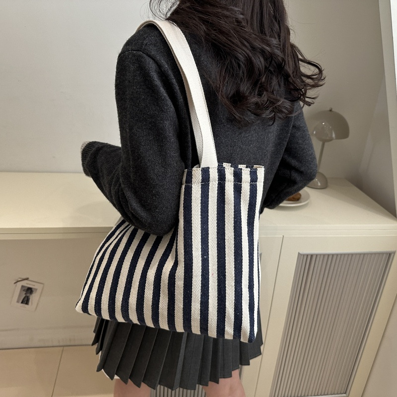 The new cross-border vertical striped commuter tote bag, hand-held shoulder bag, is fashionable and has a large capacity. It features an InS-style simple letter sail undefined