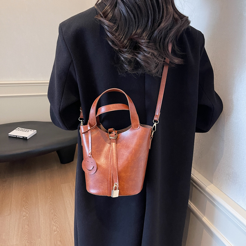 Bolso retro versátil para mujeres 2024 moda nuevo bolso de cubo de mano alta textura de transporte aéreo bolso de mochila