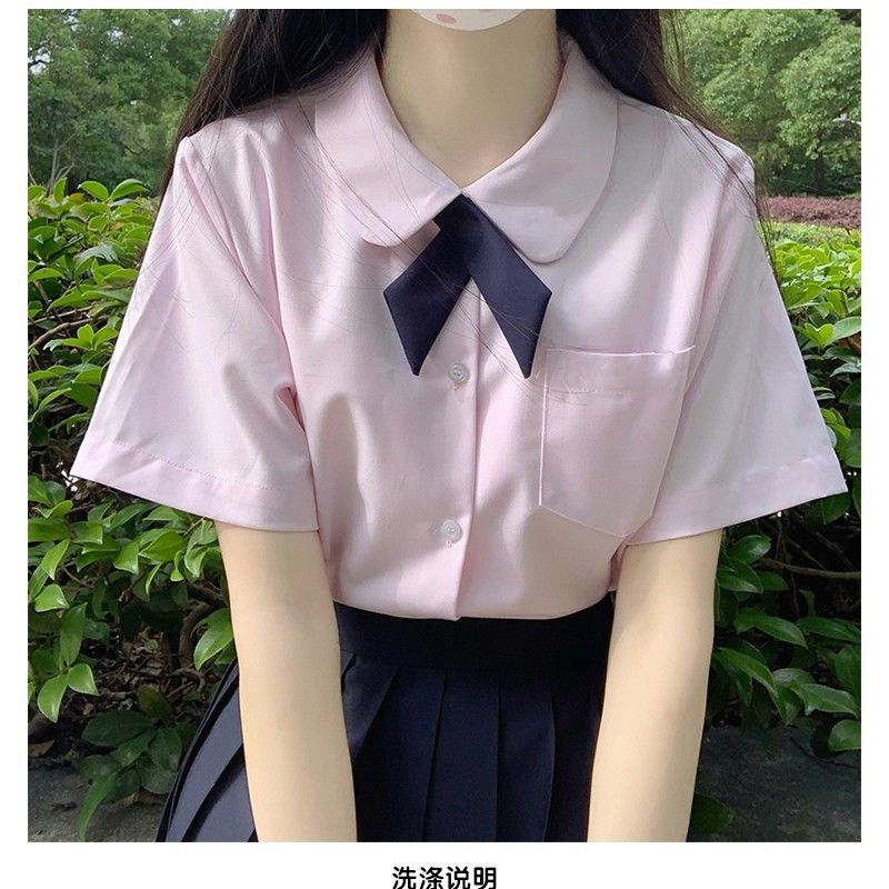 핑크색 라운드넥 반팔 셔츠와 네이비 블루 크로스 타이가 함께 제공됩니다.