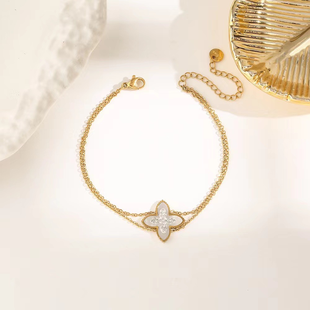 Pulsera de trébol de acero titanium vendedora caliente transfronteriza europea y americana con incrustaciones de concha pulsera colgante pulsera de diseño avanzado sin desvanecimiento al por mayor