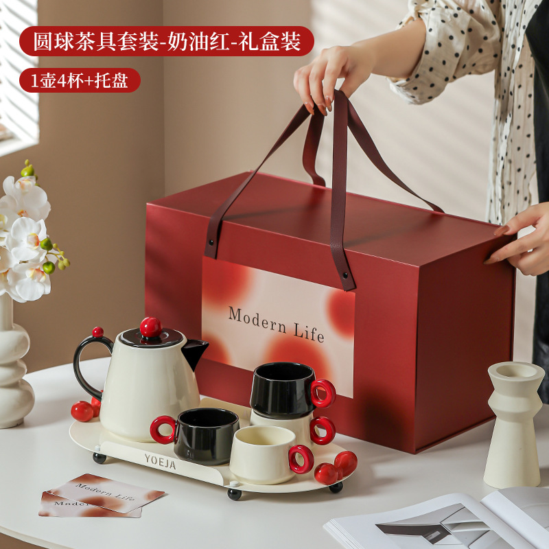 La ama de casa moderna es la misma creativa encantadora de alto valor de la cara con un conjunto de utensilios de agua de cerámica doméstica para invitados con un conjunto completo de tetera de té