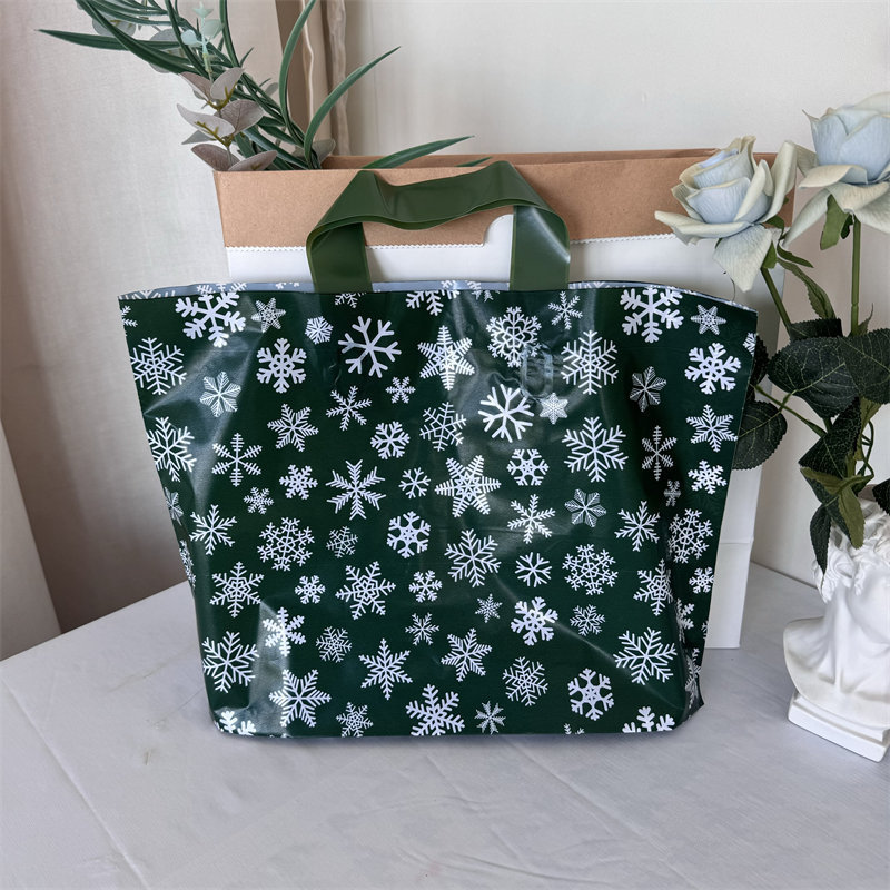 クリスマスの祝日の緑の厚いプラスチックの贈り物の服の店は手提げの袋の包装で厚いショッピングを包装して祝い事を包装します。|undefined