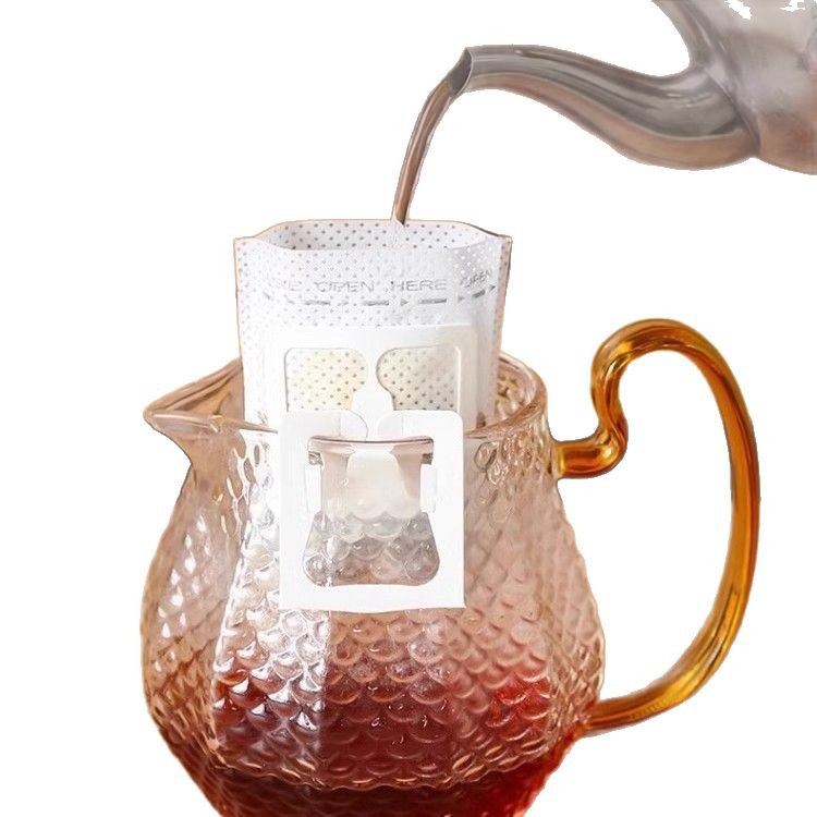 コーヒーろ紙の耳のろ紙の手でコーヒーの粉の濾過紙を流します。