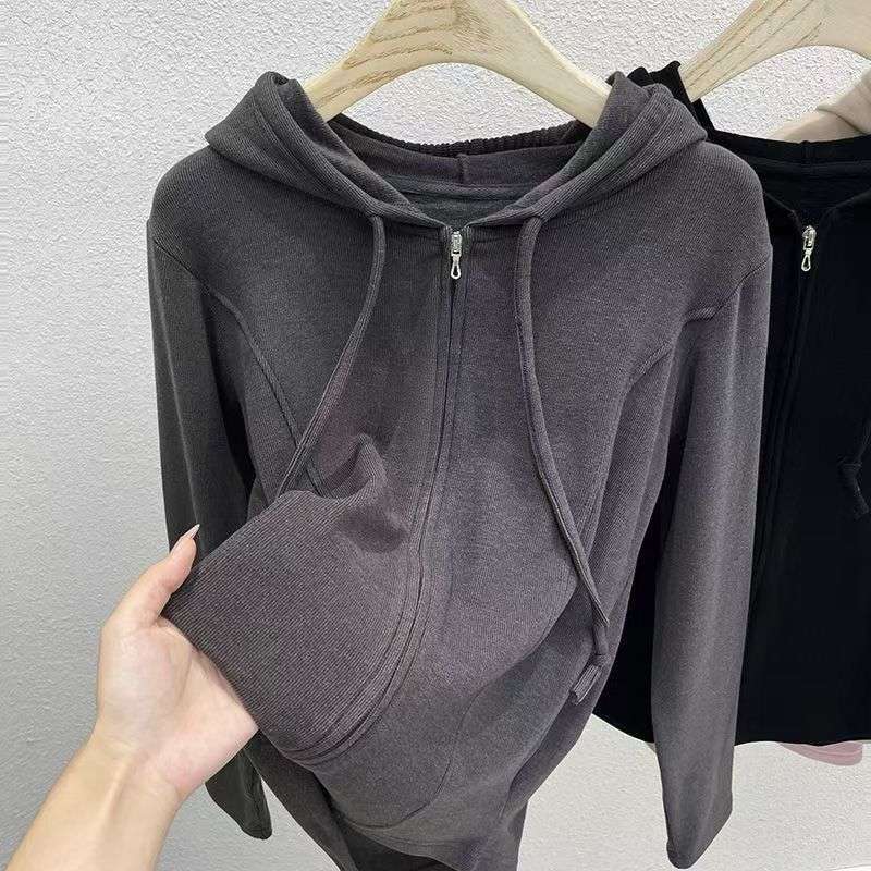 Plus-size women's hooded sweatshirt with a solid color design, unique fishbone pattern, structured shoulders, slimming effect, and a zip-up front