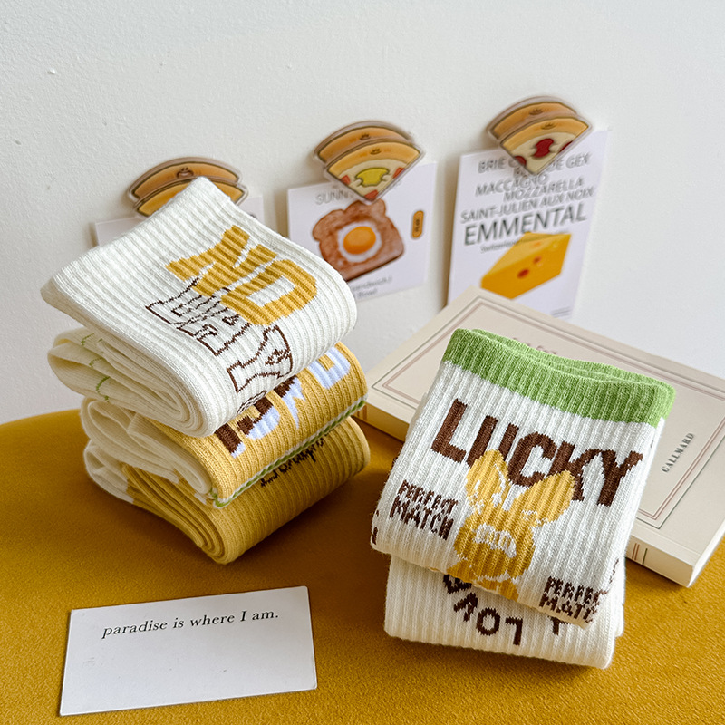 Calcetines de algodón de color puro Mediados de la pantorrilla de las mujeres Otoño e invierno Letras blancas Calcetines de marea de alta elástico Calcetines deportivos al por mayor