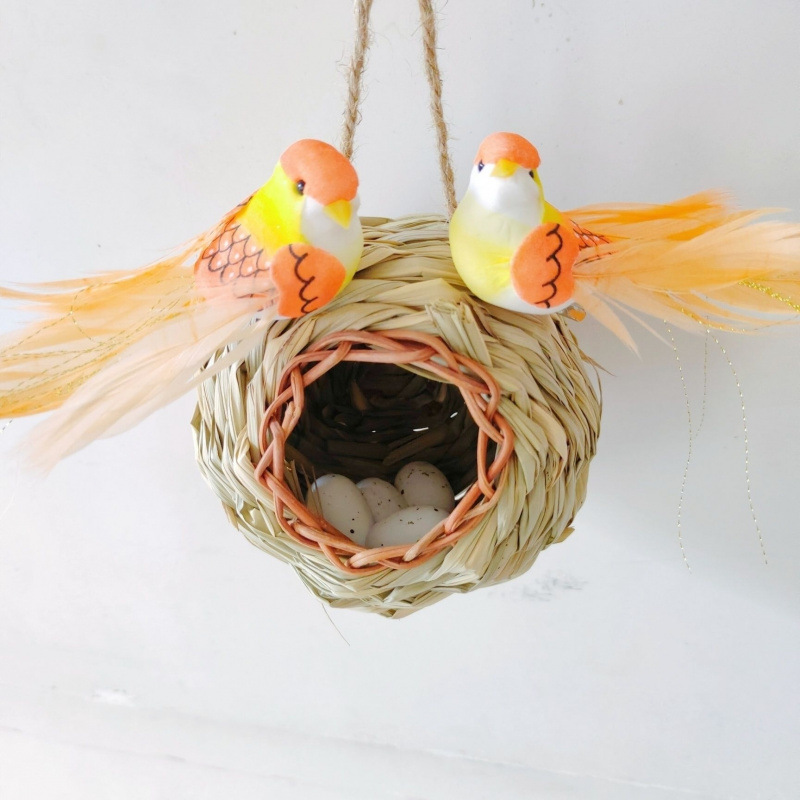 짚으로 짠 둥근 새 둥지와 두 마리의 주황색 뽀루스