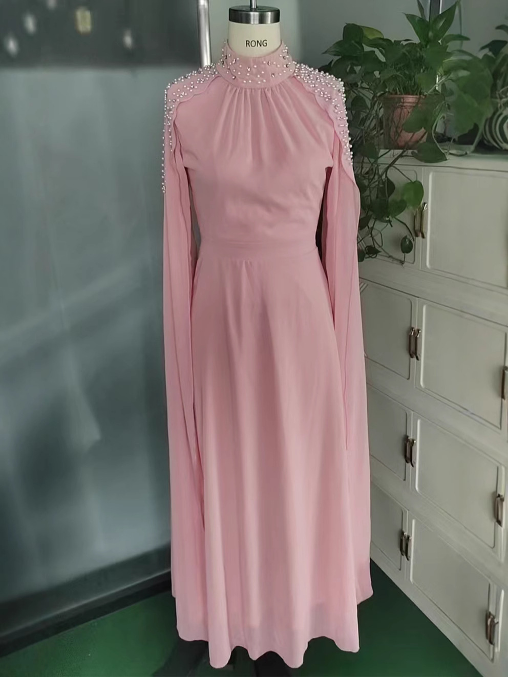 Abbigliamento da donna transfrontaliero 2026, temperamento sexy, gonna lunga alla moda con colletto rialzato, tuta in stile resort pieghettata con perline fino al pavimento