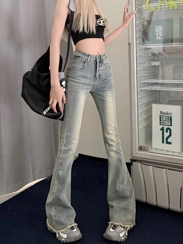 Slightly flared denim jeans for women: vintage autumn style, high waist, slimming fit, with a niche design and raw-edge hem.