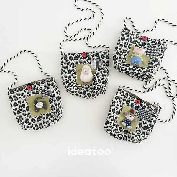 Children's autumn and winter crossbody bag, featuring a leopard print fabric design, cartoon character appliqués, and a small pouch for coins and other small items