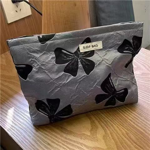 회색 배경에 검은색 리본이 달린 화장품 가방