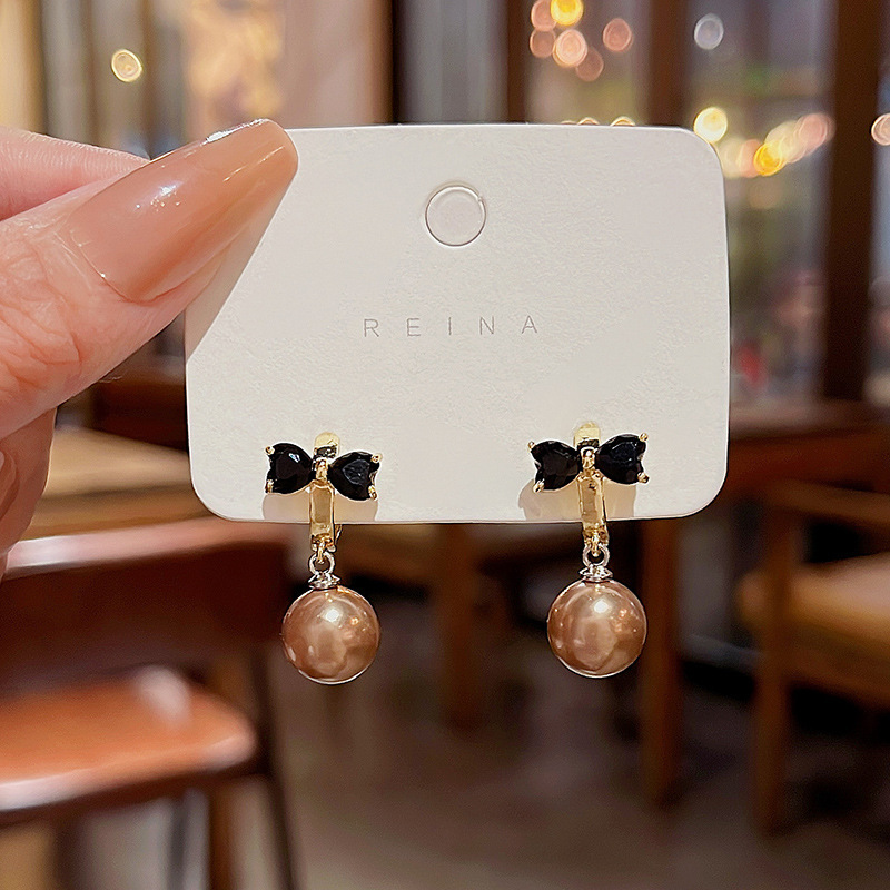 S925 aguja de plata Luz de lujo nicho pendientes de perlas de alto grado versátil elegante exquisito diamante incrustado arco pendientes