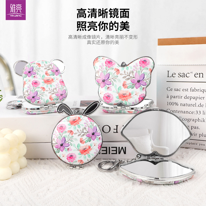 Suministro directo de fábrica de una variedad de formas, bolsa colgante, espejo de princesa, espejo de cuero de impresión de doble cara, espejo plegable, bolsa colgante, llavero de espejo