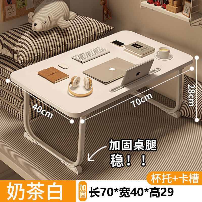 ベッドの上の小さい机のノートパソコンの机の上で折り畳みます。|undefined