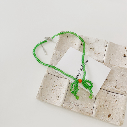 A minimalist and stylish green butterfly knot necklace for women, featuring small, fresh and elegant glass crystal beads, designed as a choker or lockchain.