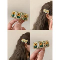 甘い秋冬の縁にかぎ針を挟んで毛糸のひまわりのヘアピンを編みます。
