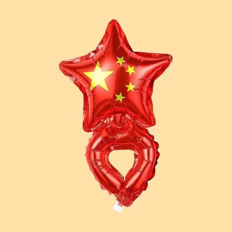 国慶節の子供は旗のカチューシャを持って腕の風船を飾って棒の幼稚園の活動の奨励地を持って贈り物を押します。|undefined