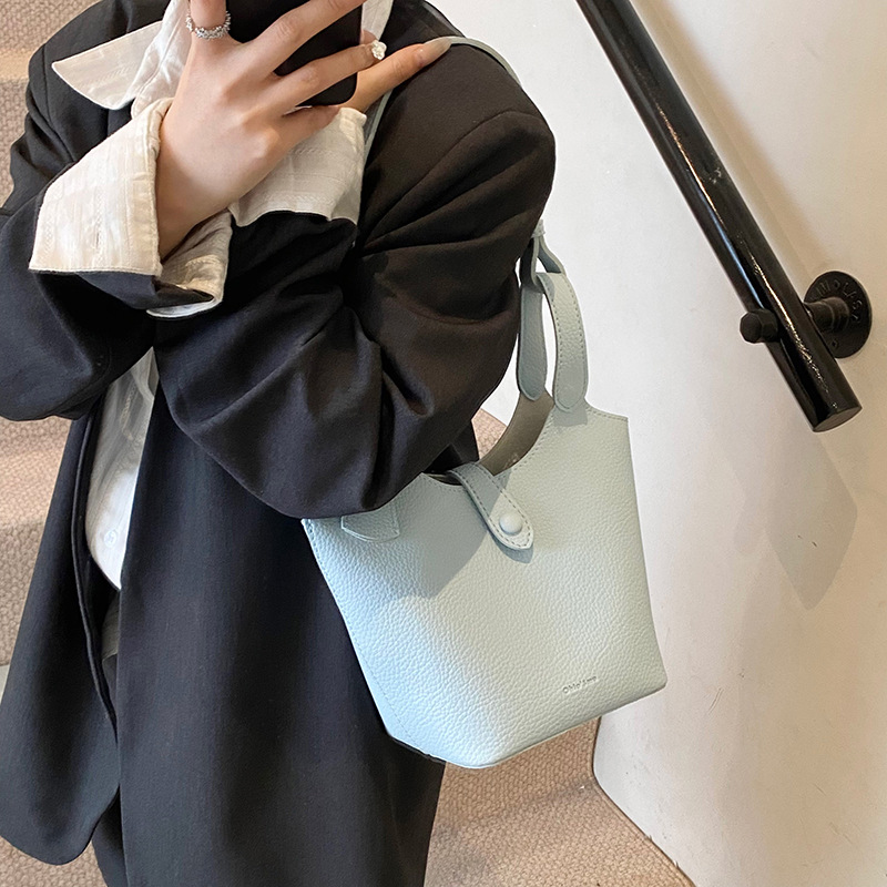 Moda coreana de gran capacidad bolsas de cubo de mano mujeres 2025 primavera y verano nueva canasta de lichi mochila de hombro