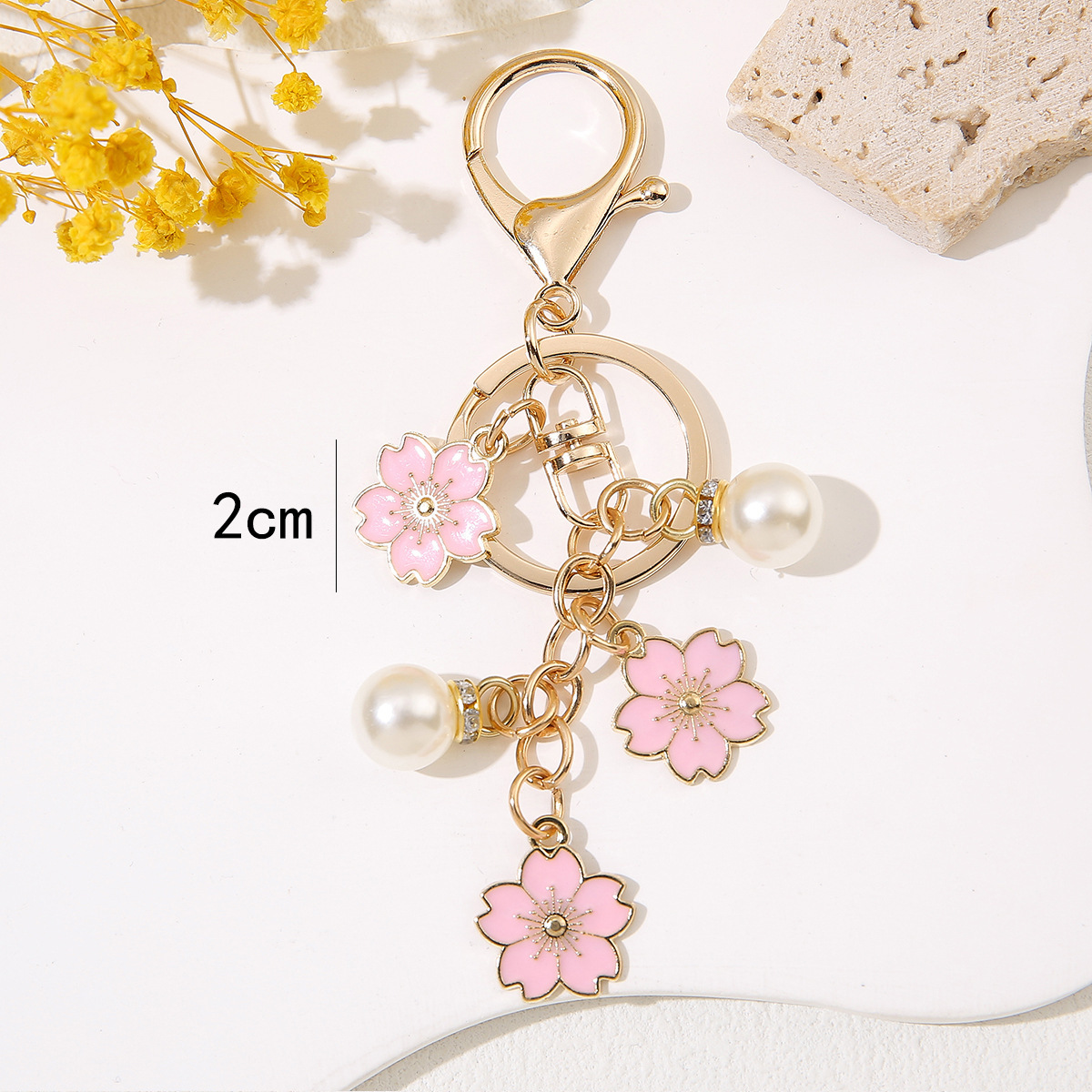 Venta al por mayor de llaveros de flores de cerezo japoneses que caen a mano, adornos de bolsos de mujer que gotean aceite, colgantes de perlas para parejas de novias