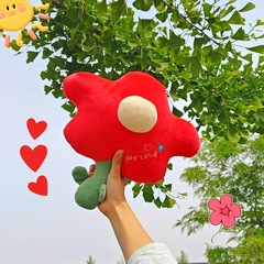創意的な赤い花のぬいぐるみのチューリップの花は枕を抱いてベッドの上で枕を支えます。