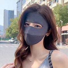 夏の女性の日焼け止めマスクの顔はキニと屋外で運転します。