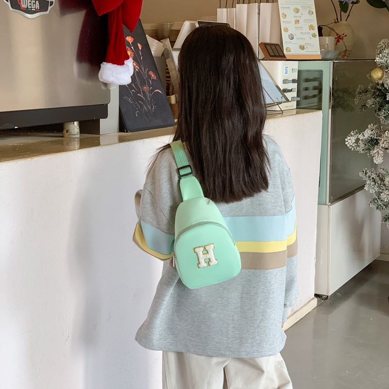 2026 nuevo bolso infantil de comercio exterior letras de moda coreana bolso de pecho para niños y niñas bolso de cinturón casual de color sólido