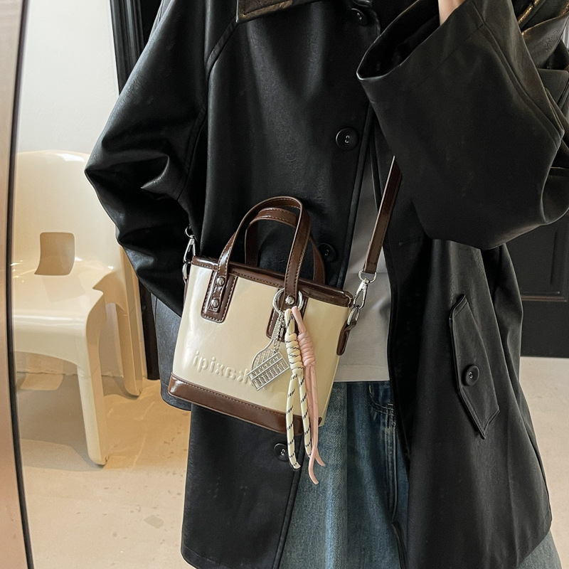Retro brillante bolso de cubo de mano 2025 nuevo estilo bolso de hombro de color contrastante sensación de alto nivel bolso de mochila casual simple