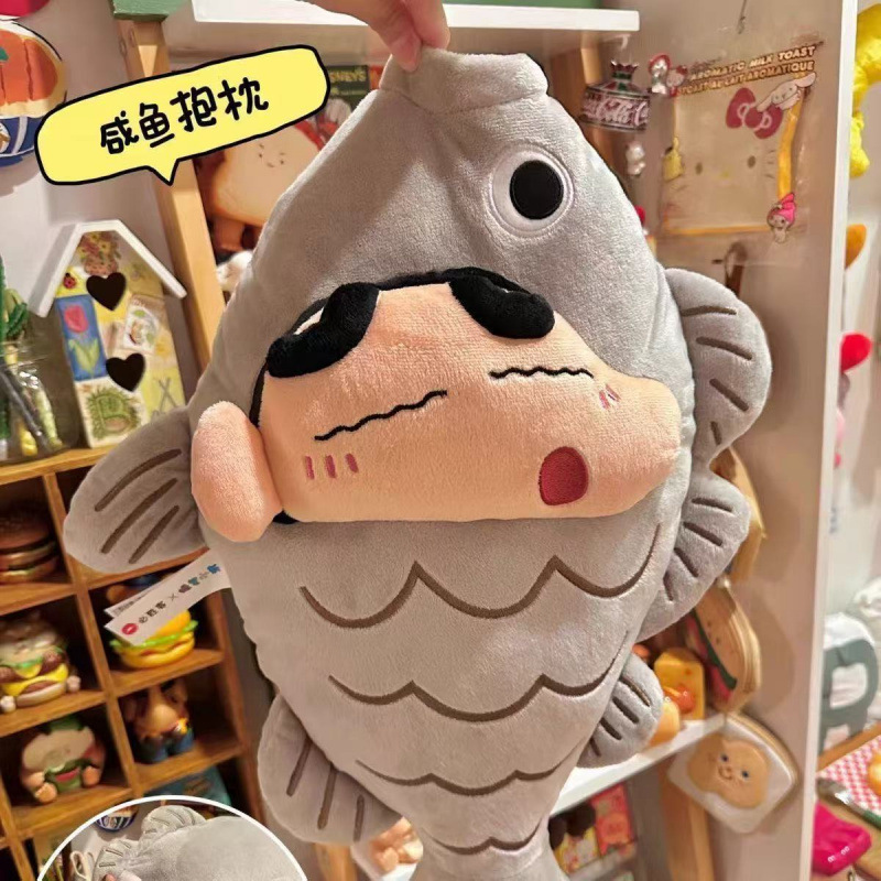 クレヨンしんちゃんのぬいぐるみぬいぐるみの小魚is小衆の机の上に物を並べて誕生日の祭りに友達を送ります。|undefined