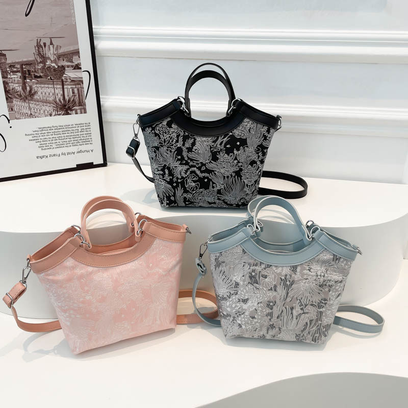 Nueva bolsa de mano de estilo chino para mujeres 2025 primavera nueva seda bordada de hombro único bolso de cubo de estilo occidental