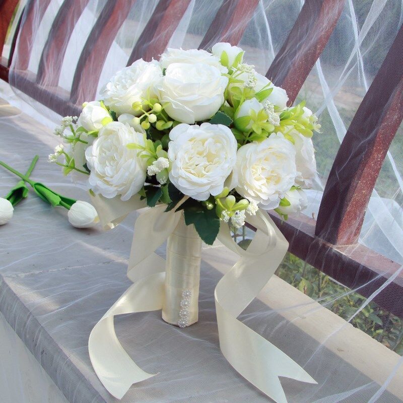 手に花を持つ新婦の韓国式結婚式の領収書のシミュレーションの花束の森系のウェディングドレスの撮影の道具の手に花をささげます。|undefined