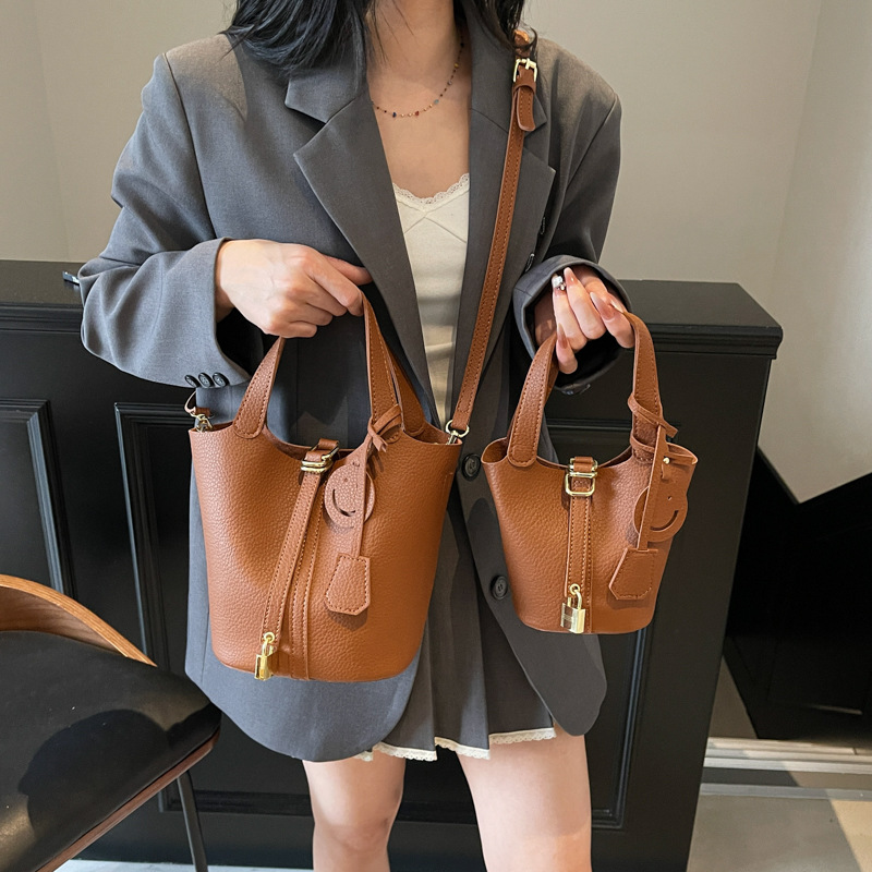 Bolso de cubo portátil con patrón de lichi de alta gama para mujer 2025 nuevo bolso de hombro de todo fósforo de moda bolso de mensajero casual de estilo occidental