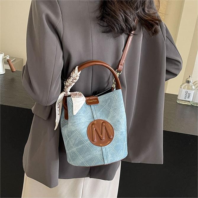 Bolso de mano popular de este año, dama, primavera y verano, 2026 nuevo bolso de cubo de vaquín universal, nicho de textura, mochila