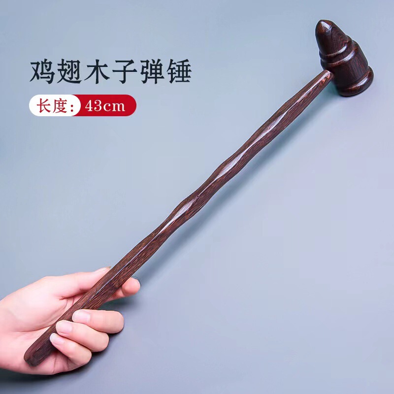 黒い鶏の羽の木のマッサージのハンマーは背中をたたいてマッサージします。|undefined