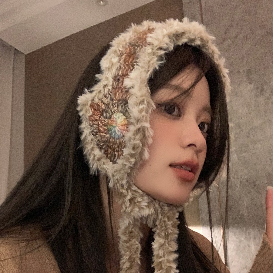 ニットの毛糸の耳カバーの女性は冬の毛がふわふわしています。耳カバーを厚くして保温しています。