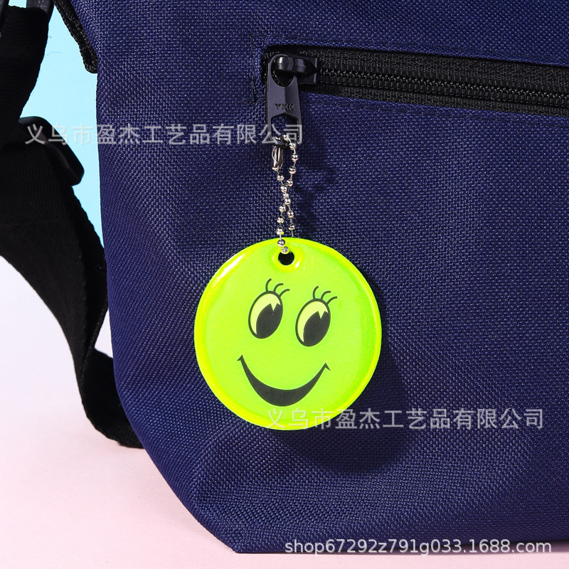 Muchos colgantes reflectantes transfronterizos sonrientes para niños viajan por la noche PVC seguro al aire libre