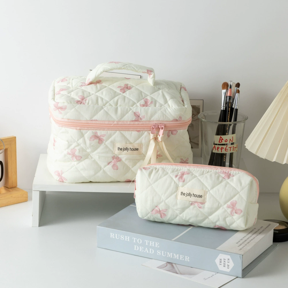 Стеганая сумка для макияжа с баночками на белом фоне