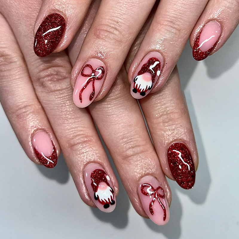 Medium almond-shaped Christmas nail art with red glitter, bow, and French manicure, featuring a cute Santa Claus design