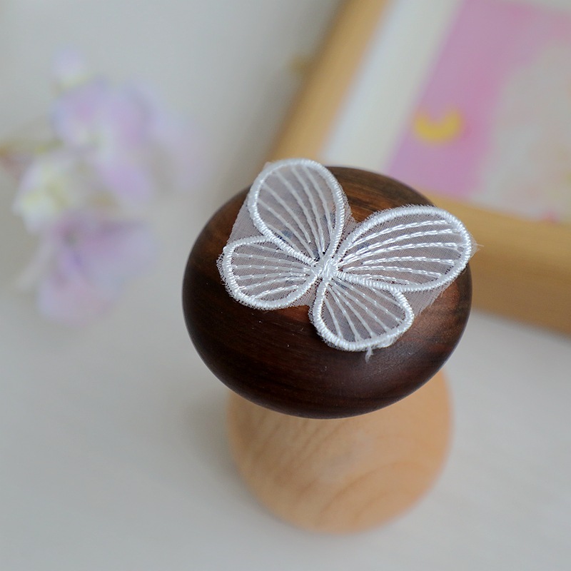 The butterfly is larger, 5.2cm wide